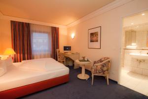 Cette chambre comprend un lit et un bureau. dans l'établissement Hotel Weißes Roß, à Marienberg