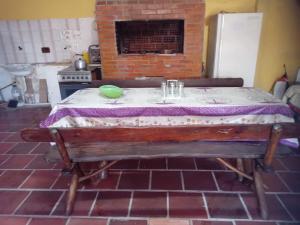una mesa en una cocina con chimenea de ladrillo en Aluguel da Léo, en Cidreira