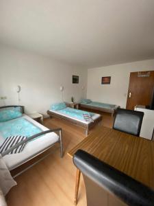 a room with two beds and two chairs in it at Monteurzimmer - Karlsbad in Karlsbad