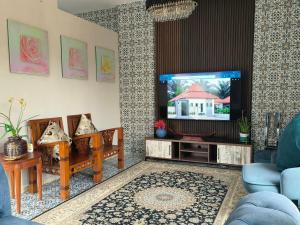 a living room with a tv and a blue couch at Laman Zavilla Dhoma 2 in Bagan Lalang