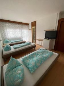 a room with two beds and a flat screen tv at Monteurzimmer - Karlsbad in Karlsbad
