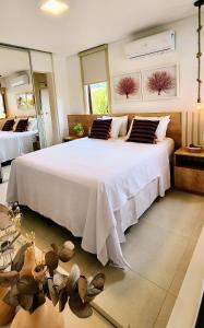 a bedroom with a large white bed with pillows at Casa Luxo com piscina privativa próximo a Igrejinha - Com colaboradora e enxoval in Praia dos Carneiros