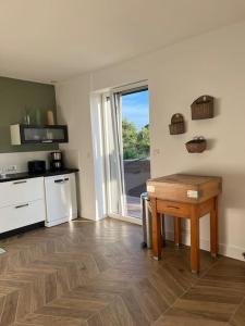 Cette chambre comprend une cuisine avec une table et une fenêtre. dans l'établissement La Maison de Kertouez - La Foret, à La Forêt-Fouesnant