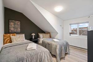 1 dormitorio con 2 camas y ventana en Venture Vacations - Best Possible Location-Laugavegur Luxury Loft, en Reikiavik