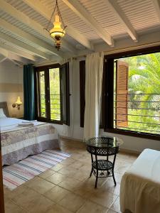a bedroom with a bed and a table and windows at Villa Rena in Vourvourou