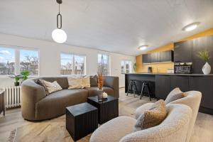 a living room with two couches and a kitchen at Venture Vacations - Best Possible Location-Laugavegur Luxury Loft in Reykjavík