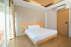 Un dormitorio con una gran cama blanca y una ventana en Casa de Coral Boutique Hotel, en Kata Beach