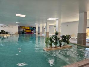 una piscina con plantas en medio de un edificio en Camping La Marmotte en Savignac-les-Ormeaux