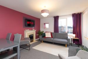 ein Wohnzimmer mit einem Sofa und einem Kamin in der Unterkunft Comfy 2BR Apartment with Balcony - Waterlily in Coventry