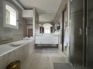 łazienka z wanną, umywalką i prysznicem w obiekcie La Villa M à Pramousquier w mieście Le Lavandou