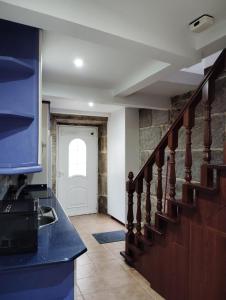 una cocina con una escalera que conduce a una puerta en CASA BOURELA, en Cangas de Morrazo