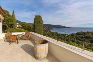 balkon ze stołem i krzesłami oraz oceanem w obiekcie La Villa M à Pramousquier w mieście Le Lavandou