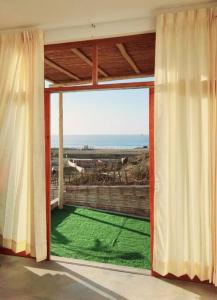 Cette chambre dispose d'une grande fenêtre avec un champ vert. dans l'établissement Casa del Norte: Casa del Norte: Mediterranean Charm in Lobitos, Peru - Ideal Surf Haven for All Levels, à Lobitos 27 autres photos
