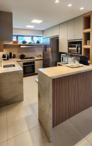 a large kitchen with stainless steel appliances at Casa Luxo com piscina privativa próximo a Igrejinha - Com colaboradora e enxoval in Praia dos Carneiros