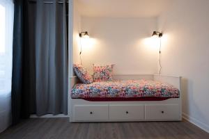Cama en habitación con 2 luces y 2 almohadas en Le Rubis - Zenith, en Toulouse