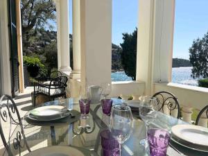 a table with wine glasses sitting on a porch at Diodato Luxury Residence Corbusier Promenade & Sea View with Pool #3 in Roquebrune-Cap-Martin
