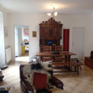 uma sala de estar com uma mesa e um sofá em La Maison Pain d'Epices em Chichilianne