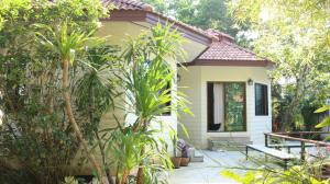a small house in the middle of a garden at Navari Homestay in Rayong