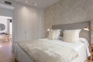 1 dormitorio con 1 cama blanca grande con almohadas blancas en Centric Puerta del sol and Canalejas III, en Madrid