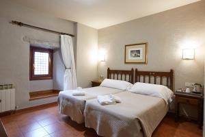 a bedroom with a bed with towels on it at Hotel Convento San Roque in Balmaseda