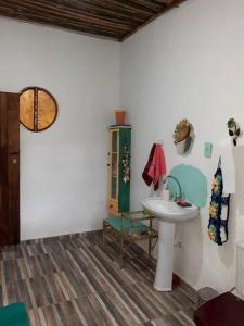 ein Bad mit einem Waschbecken und einem Spiegel in der Unterkunft Casa de campo em Embu das Artes in Embu