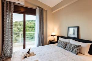 una camera con un letto e una grande finestra di Villa Armonia - Beachfront Majestic Retreat a Petalidi