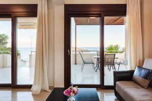 Villa Armonia - Beachfront Majestic Retreat في بيتاليدهيون: غرفة معيشة مع أريكة وإطلالة على المحيط