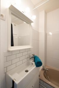 Baño blanco con lavabo y espejo en Le Rubis - Zenith, en Toulouse