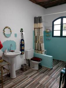 a bathroom with a toilet and a sink at Casa de campo em Embu das Artes in Embu