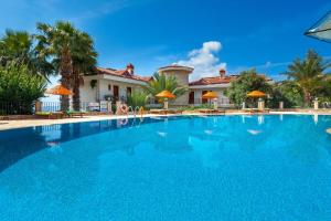 a large blue swimming pool in front of a house at Aquarius Hotel in Kaş