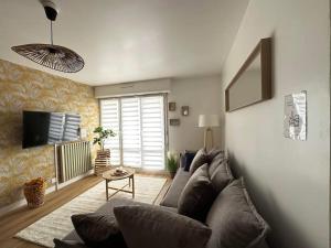 Étoile Seh'Loué في سانت بريوك: غرفة معيشة مع أريكة وتلفزيون