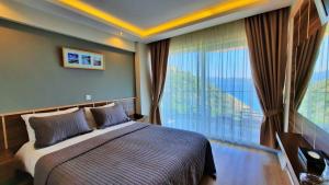 a bedroom with a bed and a large window at Aquarius Hotel in Kas