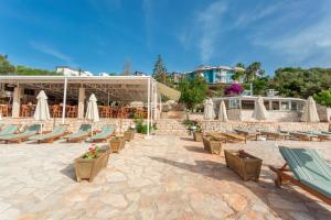 a group of lounge chairs and umbrellas on a patio at Aquarius Hotel in Kaş
