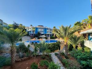 an aerial view of a resort with a swimming pool and palm trees at Aquarius Hotel in Kaş