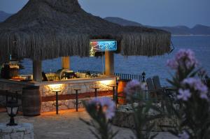 a bar with a straw umbrella and the water at Aquarius Hotel in Kaş