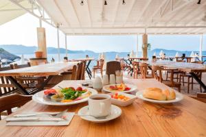 a wooden table with plates of food on it at Aquarius Hotel in Kaş