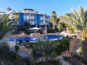 a view of a resort with a pool and palm trees at Aquarius Hotel in Kaş