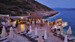 a restaurant on the beach with chairs and umbrellas at Aquarius Hotel in Kaş
