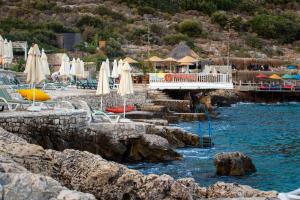 a resort with chairs and umbrellas in the water at Aquarius Hotel in Kaş
