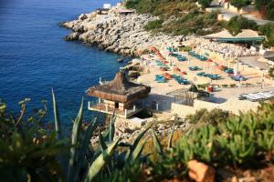 a beach with chairs and umbrellas and the water at Aquarius Hotel in Kaş