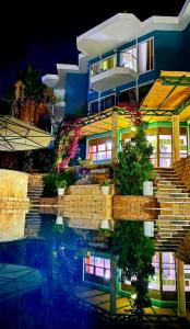 a building with its reflection in the water at night at Aquarius Hotel in Kaş