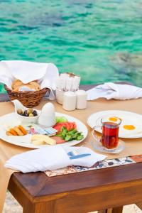 a table with breakfast food on a table by the water at Aquarius Hotel in Kaş