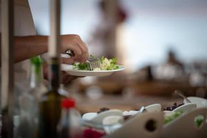 a person holding a plate of food with a fork at Aquarius Hotel in Kaş