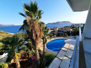 a view from the balcony of a house with a swimming pool and palm trees at Aquarius Hotel in Kaş