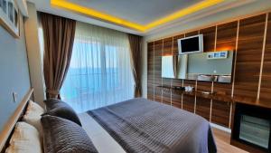 a hotel room with a bed and a tv at Aquarius Hotel in Kaş