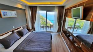 a bedroom with two beds and a large window at Aquarius Hotel in Kaş