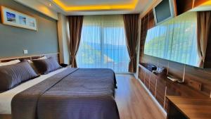 a bedroom with a large bed and a large window at Aquarius Hotel in Kaş