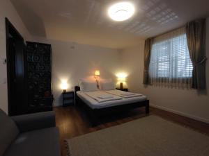 a bedroom with a bed with two lamps and a window at City-Top Panorama House & Apartments in Esztergom
