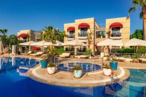 un complejo con una piscina con mesas y sombrillas en Bodrium Hotel & Spa, en Bodrum City