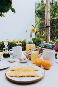 uma mesa com um prato de omeletes e laranjas em The Willow B&B em Urubamba